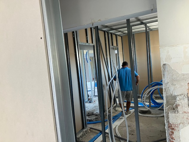 Worker moving through a framed doorway as the internal layout takes shape.