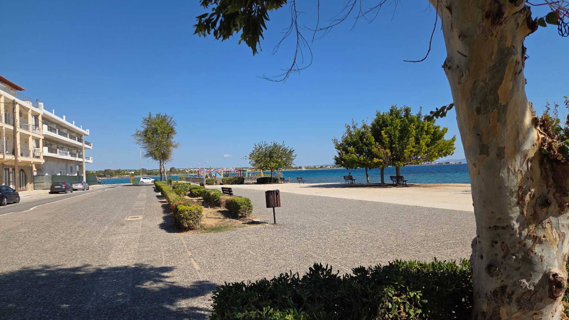 Wide view of the landscaped waterfront promenade and the sea beside the JKP Artemis setting.