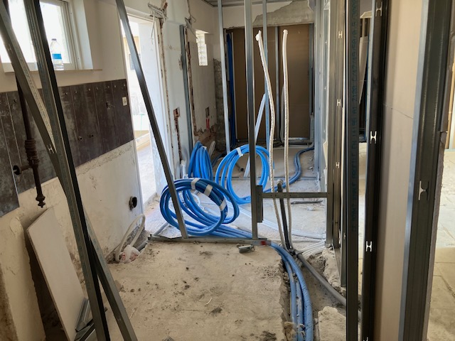 Wider internal view of service routing continuing through framed first-floor spaces.