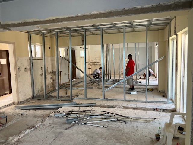 Construction team at work within the newly framed rooms.