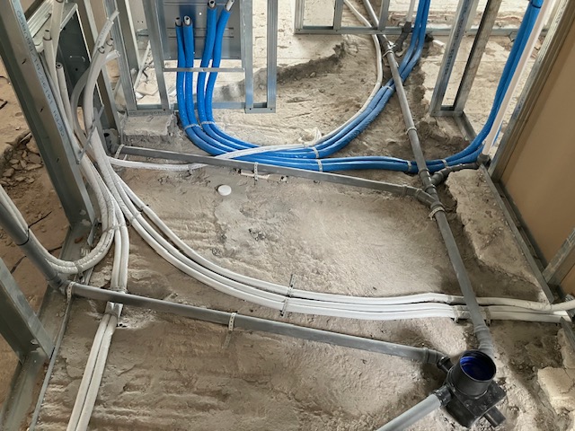 Detailed view of coordinated blue and white service lines routed through the first-floor partitions.